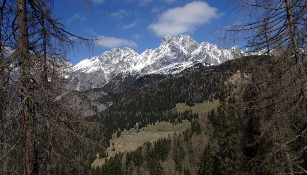 Casera Losco dalla strada di Col Rementera sullo sfondo della Cresta dei Castellati e del M. Brentoni